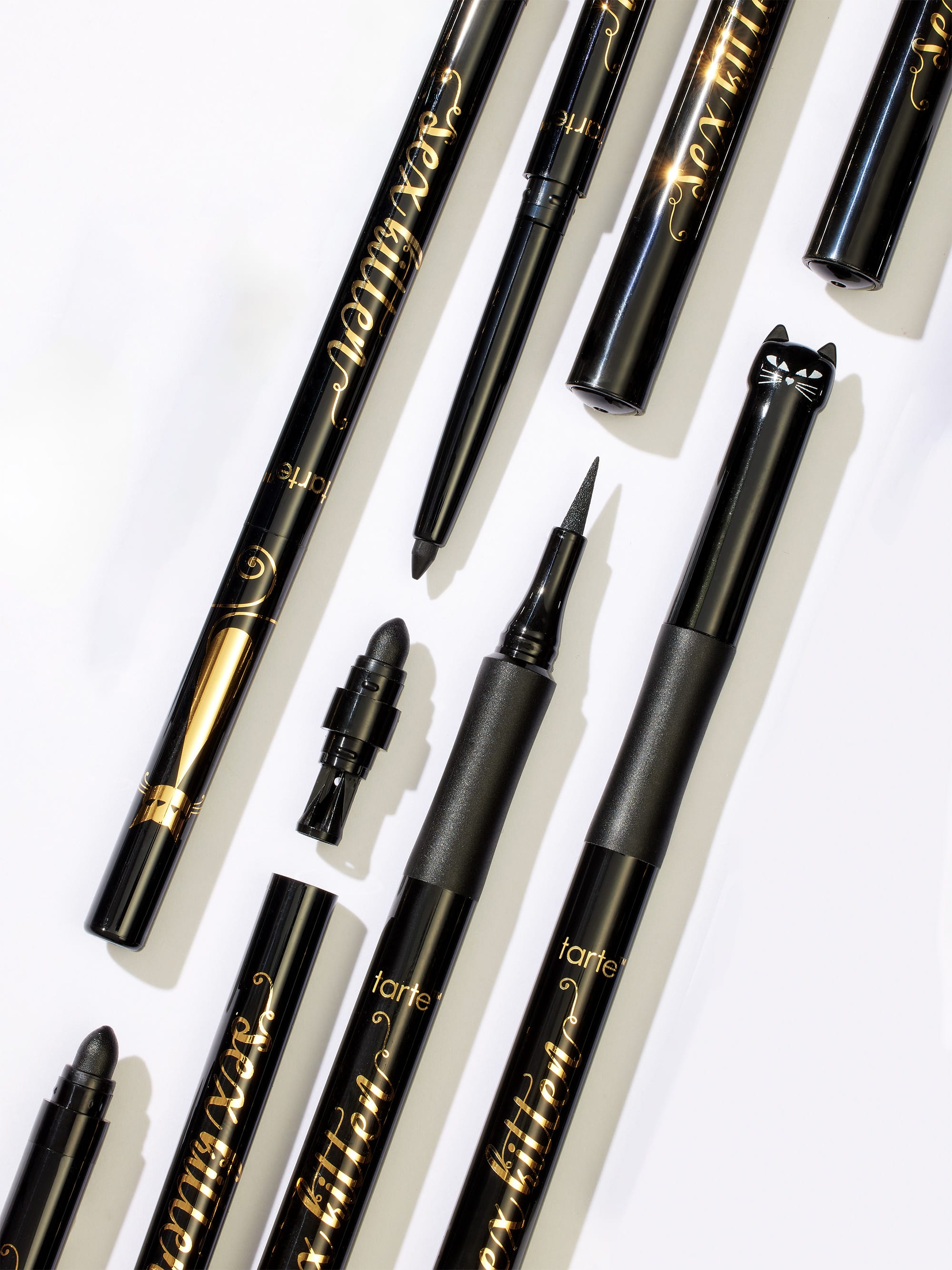 Collection of black eyeliner pens with visible branding on a white background