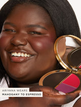 A person smiling holds an open Tarte Cosmetics compact with pink and brown shades. Text reads: ARIYANA WEARS MAHOGANY TO ESPRESSO. The background is plain white.