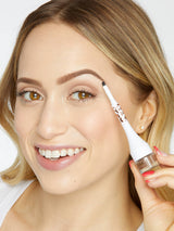 Woman applying eyeliner with a small handheld device on a white background