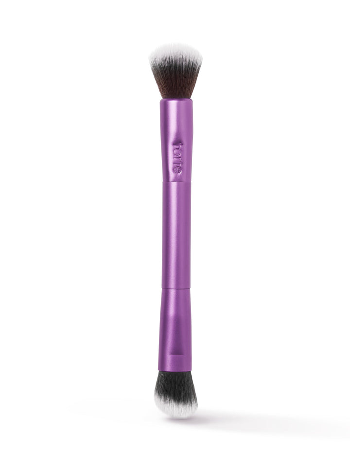 A dual-ended makeup brush with purple handle, featuring soft bristles on both ends for versatile application. Tarte is embossed on the handle, set against a white background.