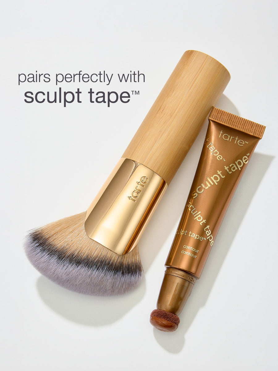 Makeup brush and 'sculpt tape' by tarte on a light gray background