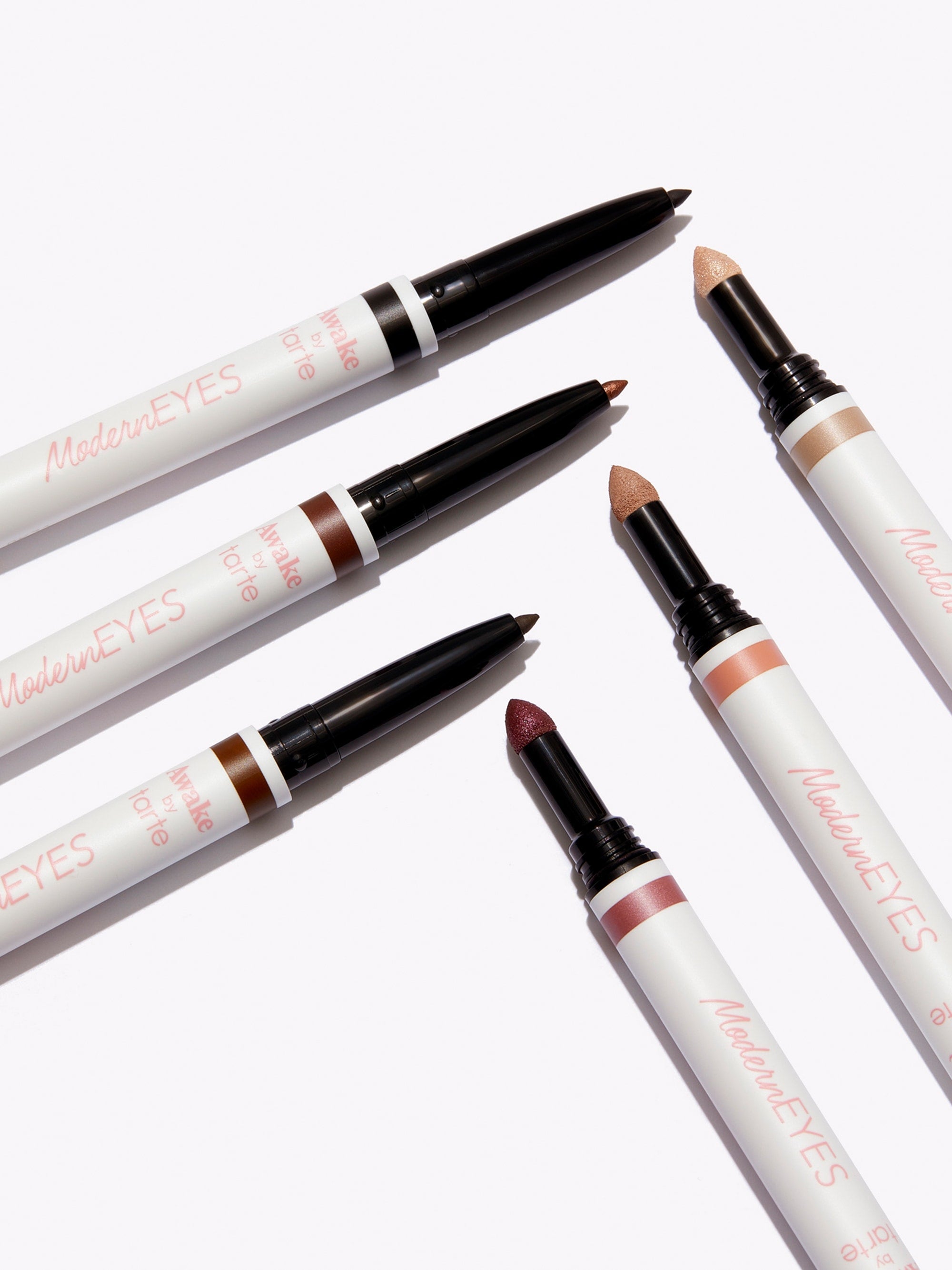 Set of makeup pencils with visible brand name on a white background