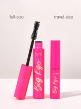 Pink mascara tubes labeled Big Ego by Tarte Cosmetics are standing upright. One tube's wand is visible. Text above them reads full-size and travel-size on a plain background.