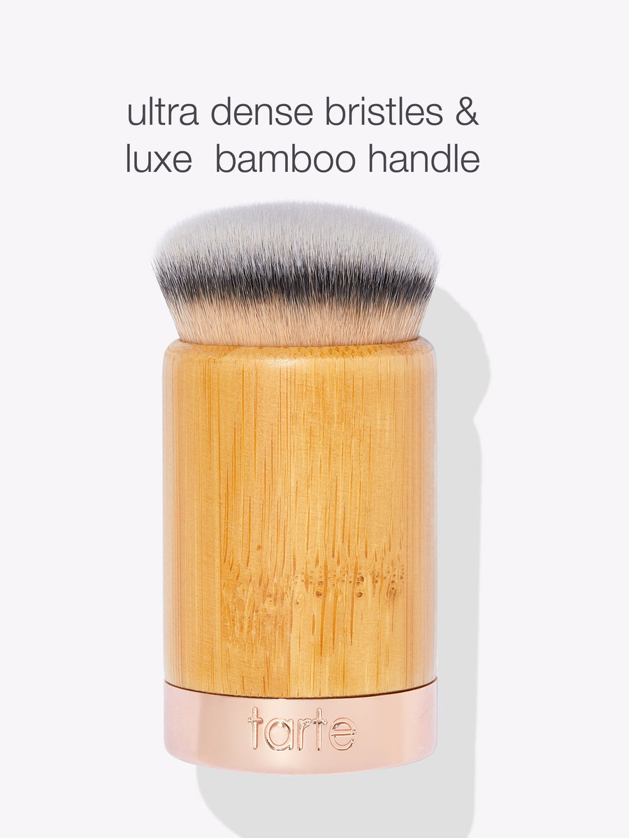 A makeup brush features ultra-dense bristles and a luxe bamboo handle, with tarte embossed on a metallic band. Text above reads: ultra dense bristles & luxe bamboo handle.