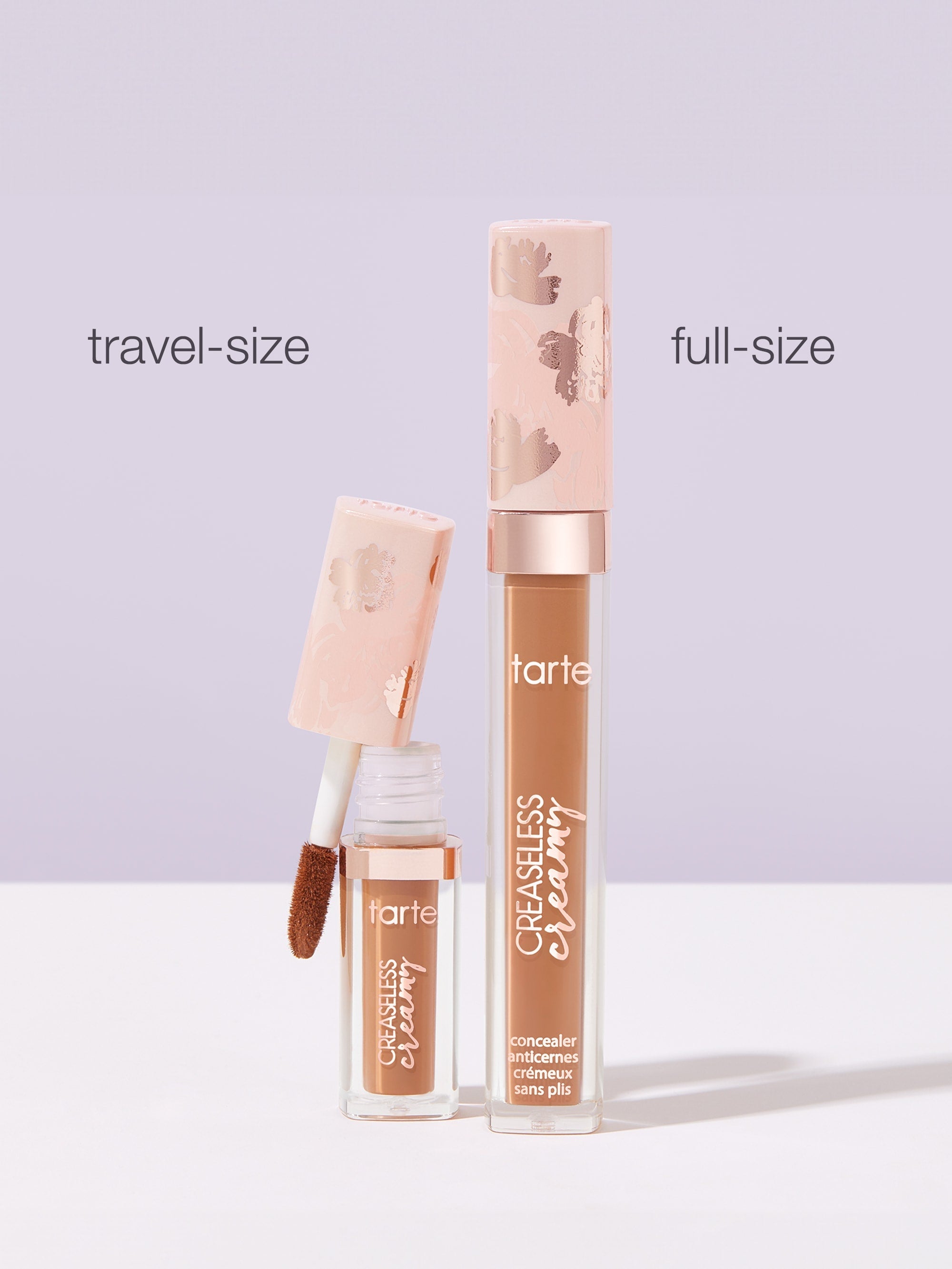 Two tubes of Tarte Cosmetics Creaseless Creamy Concealer are displayed on a pastel surface. One is travel-size with an open applicator, and the other is full-size. Text: travel-size, full-size.