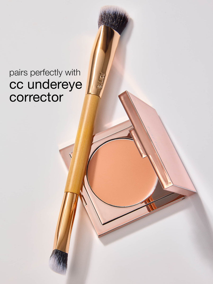 Makeup brush and compact powder with text 'pairs perfectly with cc undereye corrector' on a light background
