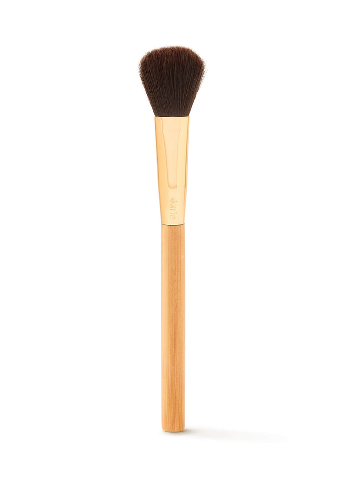 Makeup brush with wooden handle and black bristles on a white background