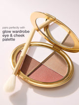 Makeup palette with a brush on a light background