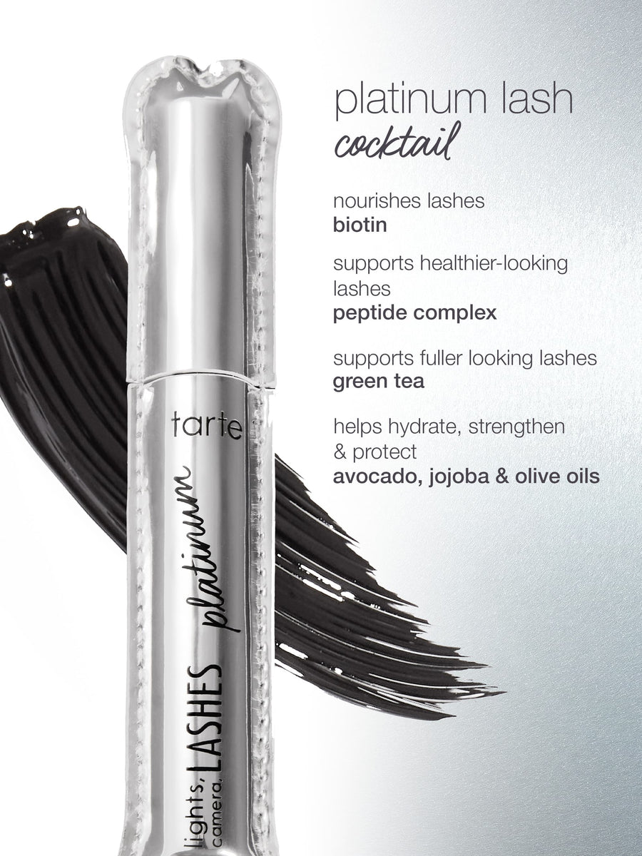 A silver Tarte Cosmetics mascara tube labeled lights, camera, LASHES platinum is placed against a backdrop of black brush strokes. The adjacent text lists ingredients: platinum lash cocktail, biotin, peptide complex, green tea, avocado, jojoba & olive oils, detailing their benefits for lashes.