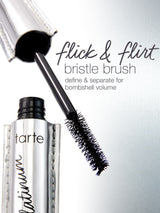 Mascara brush extending from a shiny tube labeled tarte platinum. Text reads: flick & flirt bristle brush define & separate for bombshell volume. Set against a metallic background.