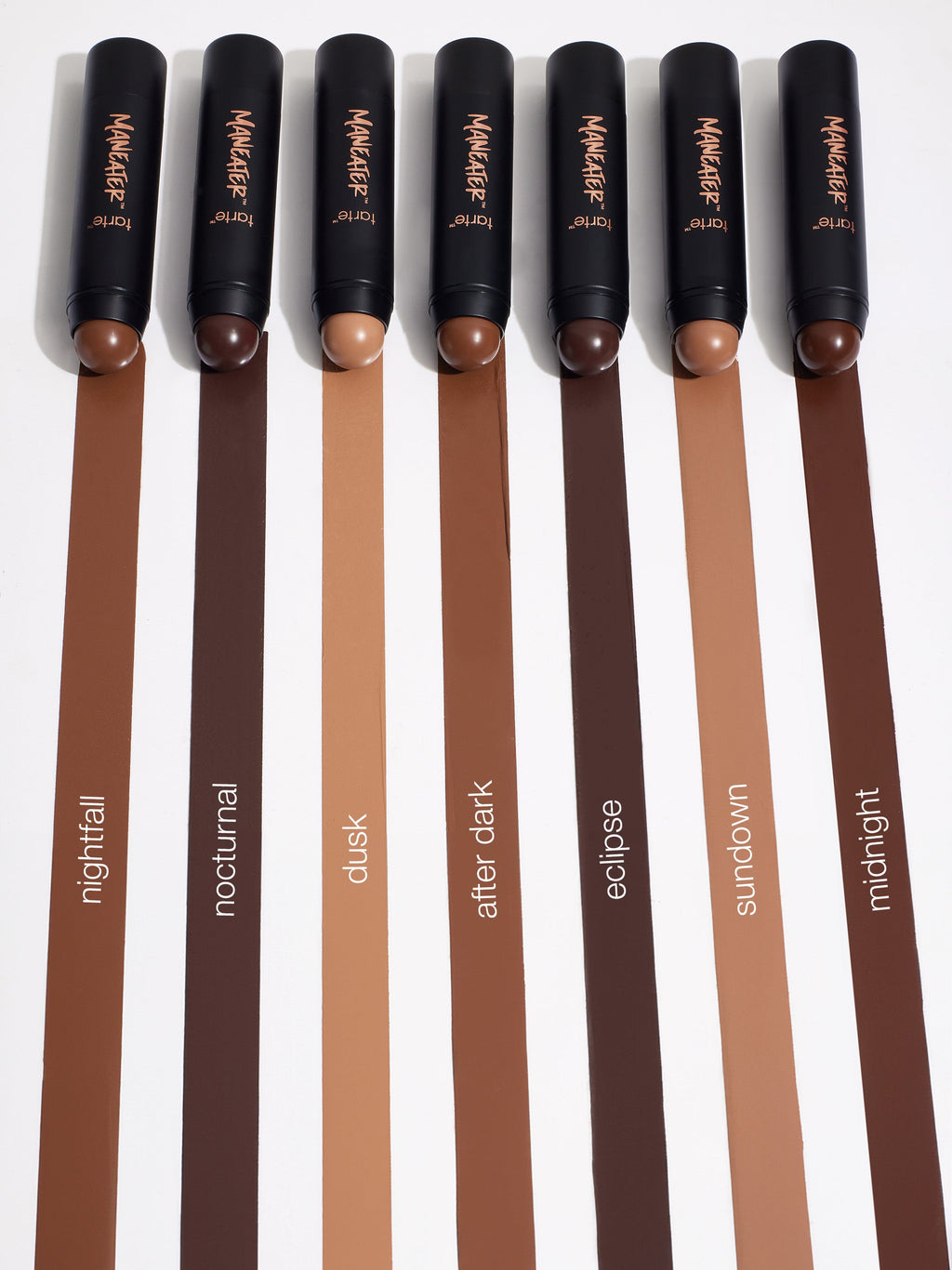 Set of makeup brushes with brown handles and visible brand name on a white background