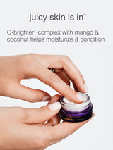Hand holding a small container of cream with text about a 'juicy skin' product.