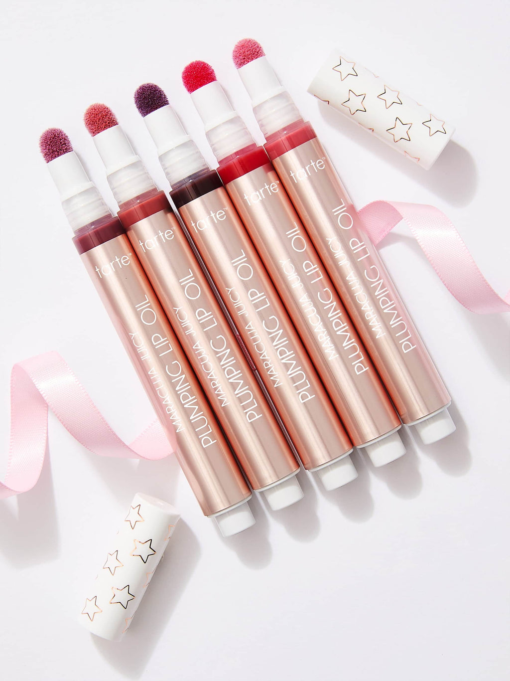 Set of tarte maracuja juicy lip plumping oils with visible brand name on a light background