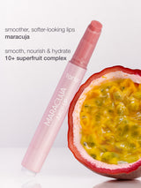 Tarte maracuja lip balm with a halved passion fruit on a white background
