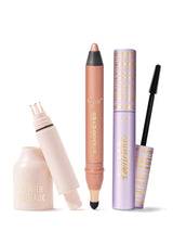 Three Tarte makeup items: a pale-pink faux-lash adhesive bottle with applicator exposed, a shimmery peach smolderEYES eye crayon, and a lavender-gold mascara tube with wand on a white background.

Text: tarte™ GO WITH THE FAUX; tarte™ smolderEYES™; tartelette