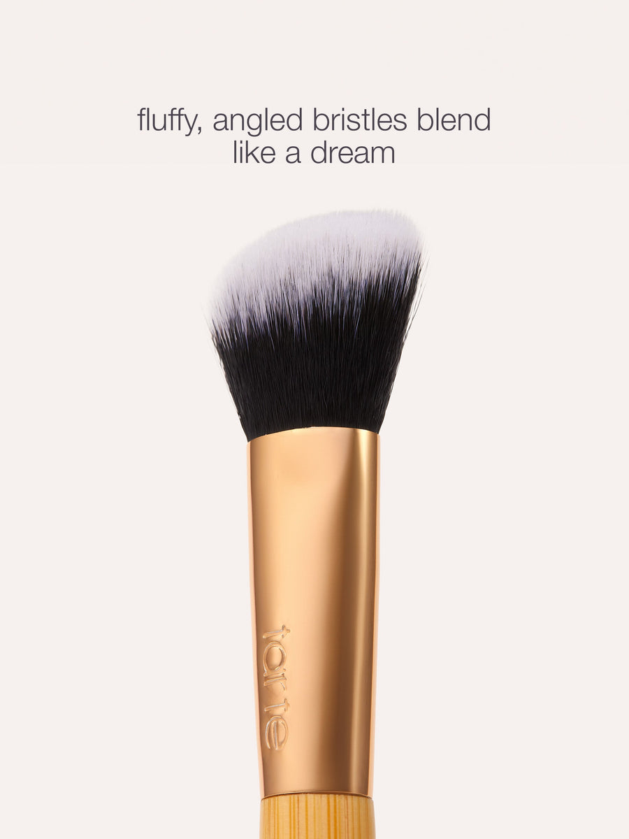 Makeup brush with fluffy, angled bristles on a white background