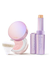 Tarte cushion compact and lavender stick stand together: compact lid open showing pink powder and puff; stick extended revealing beige product on white background. Text: tarte; shape tape BLUR