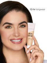 Woman holding a tube of 'skin treat' with '12-hr longwear' text on a white background