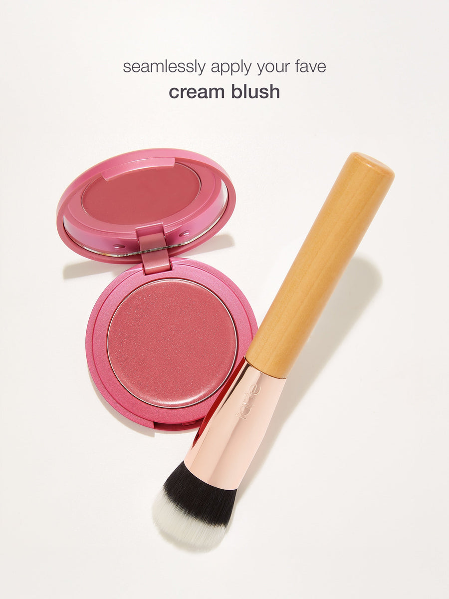 Pink cream blush with a brush on a white background