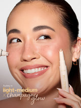Woman applying makeup with a stick, focusing on the face. using tarte cosmetics freckle stick