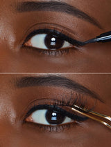 Close-up of an eye with eyeliner application using a brush.