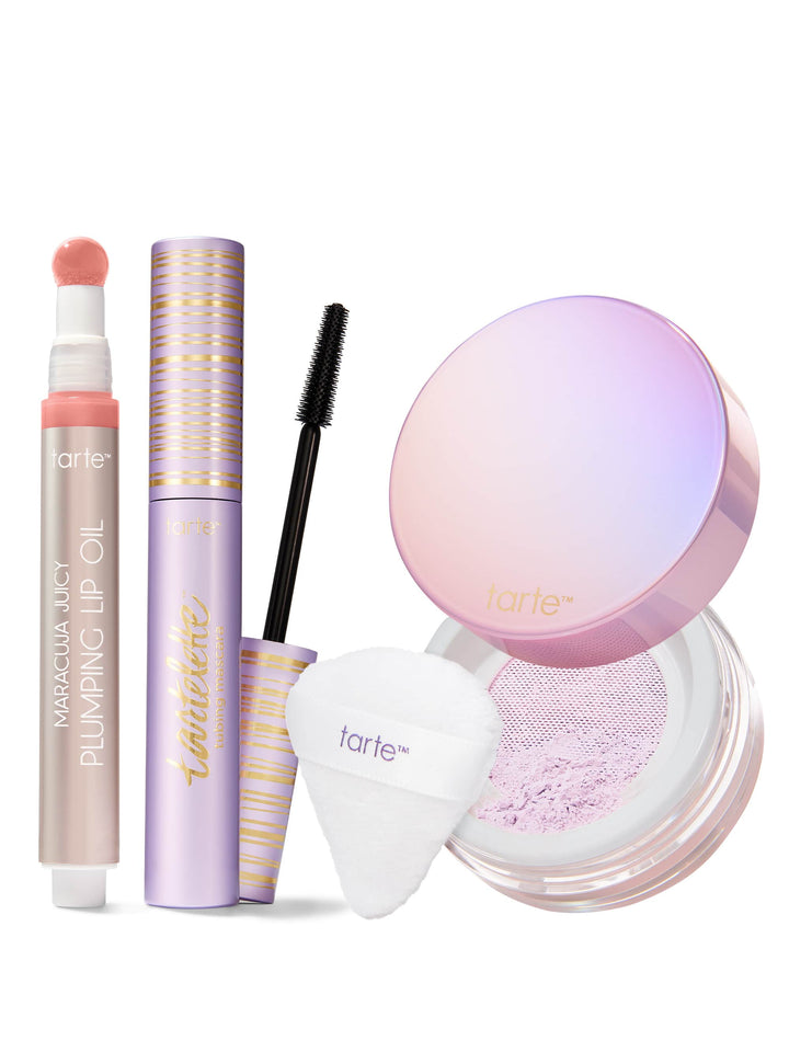 Makeup products including maracuja juicy lip oil, tubing mascara and setting powder trio with a white background