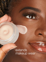 Person applying cream to face with text 'extends makeup wear'