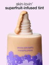 Superfruit-infused tint bottle with a dropper on a light purple background