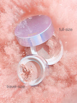 Two skincare containers, one labeled 'full-size' and the other 'travel-size', on a pink textured background.