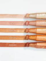 Set of makeup brushes with different colored glows on a white background