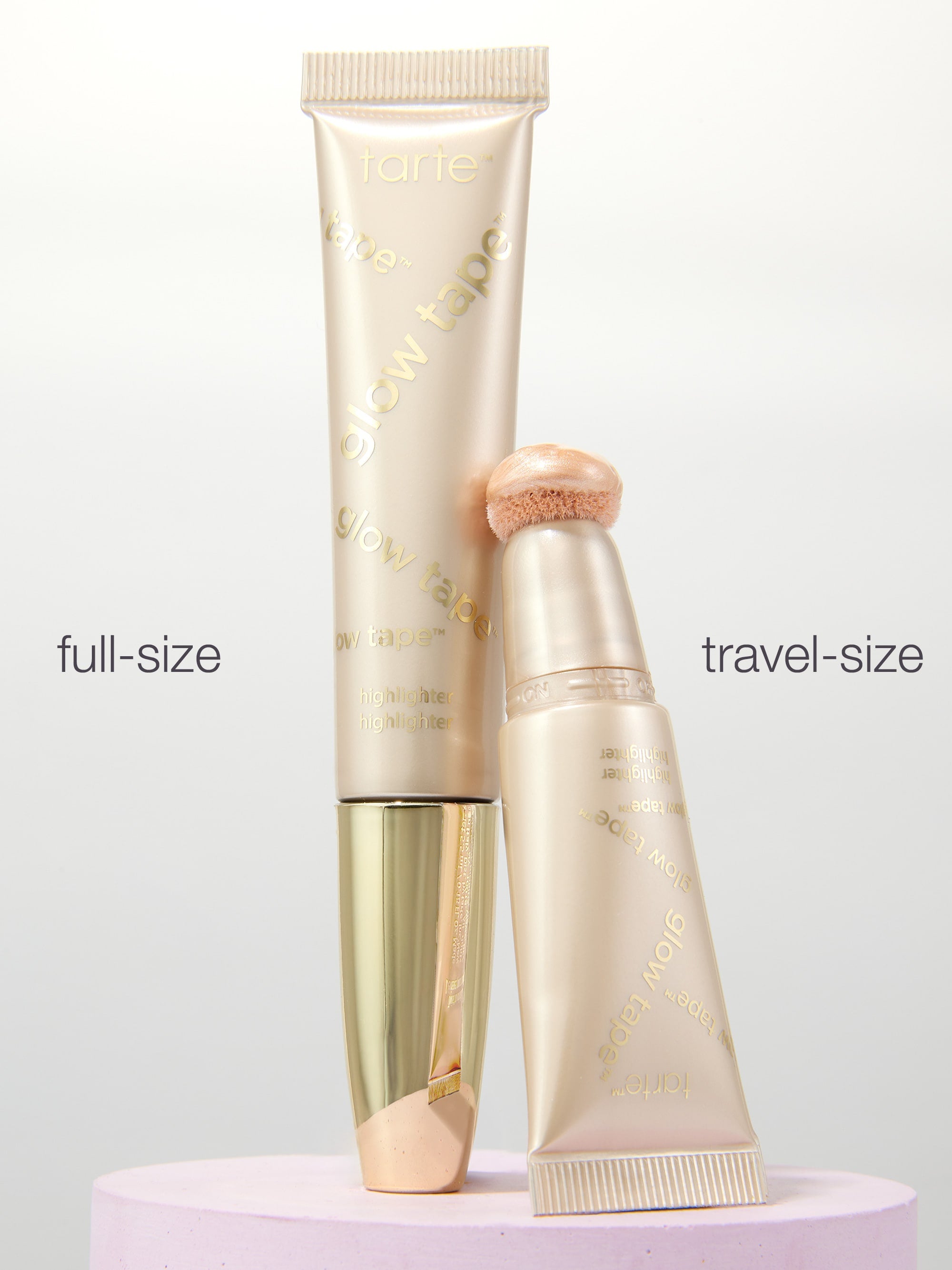 Full-size and travel-size cosmetic tubes on a light gray background