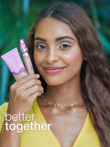 Woman holding two cosmetic products with 'better together' text against a blurred natural background