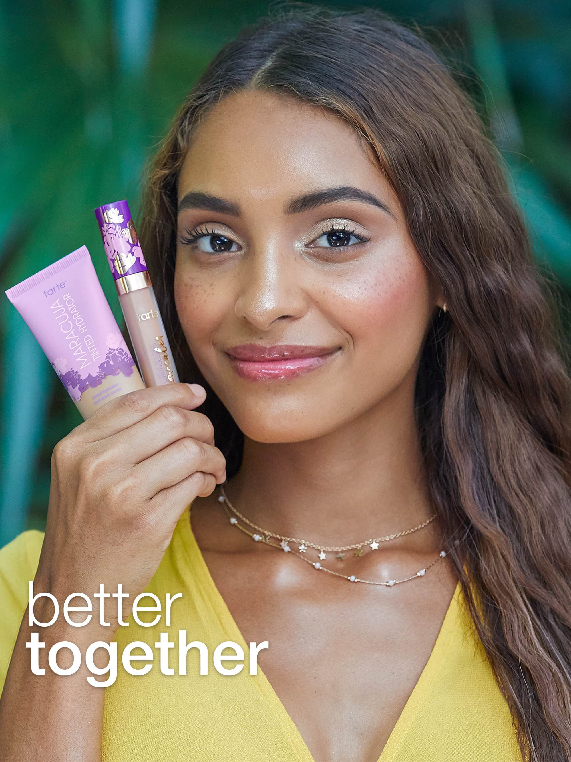 Woman holding two cosmetic products with 'better together' text against a blurred natural background