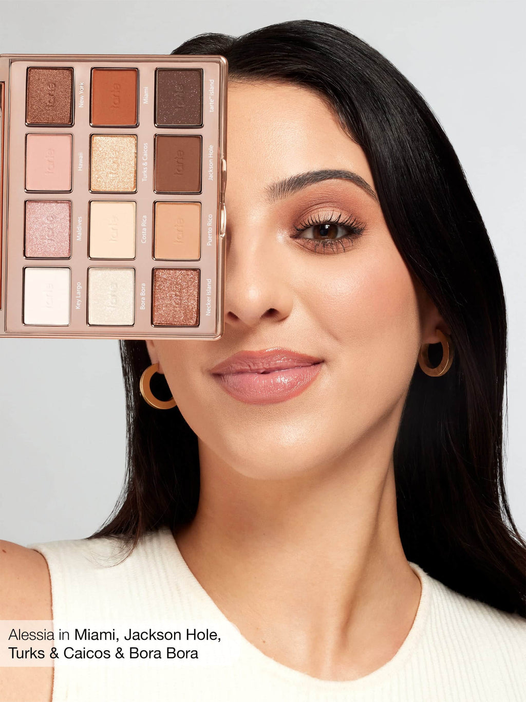 Woman with makeup palette over her face, with a neutral background