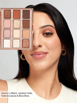 Woman with makeup palette over her face, with a neutral background