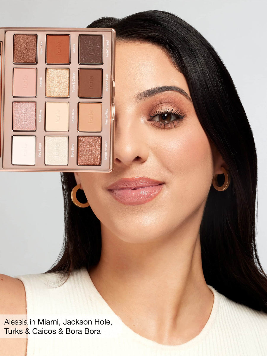 Woman with makeup palette over her face, with a neutral background