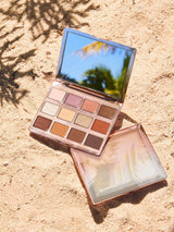 Makeup palette with a mirror on a sandy surface