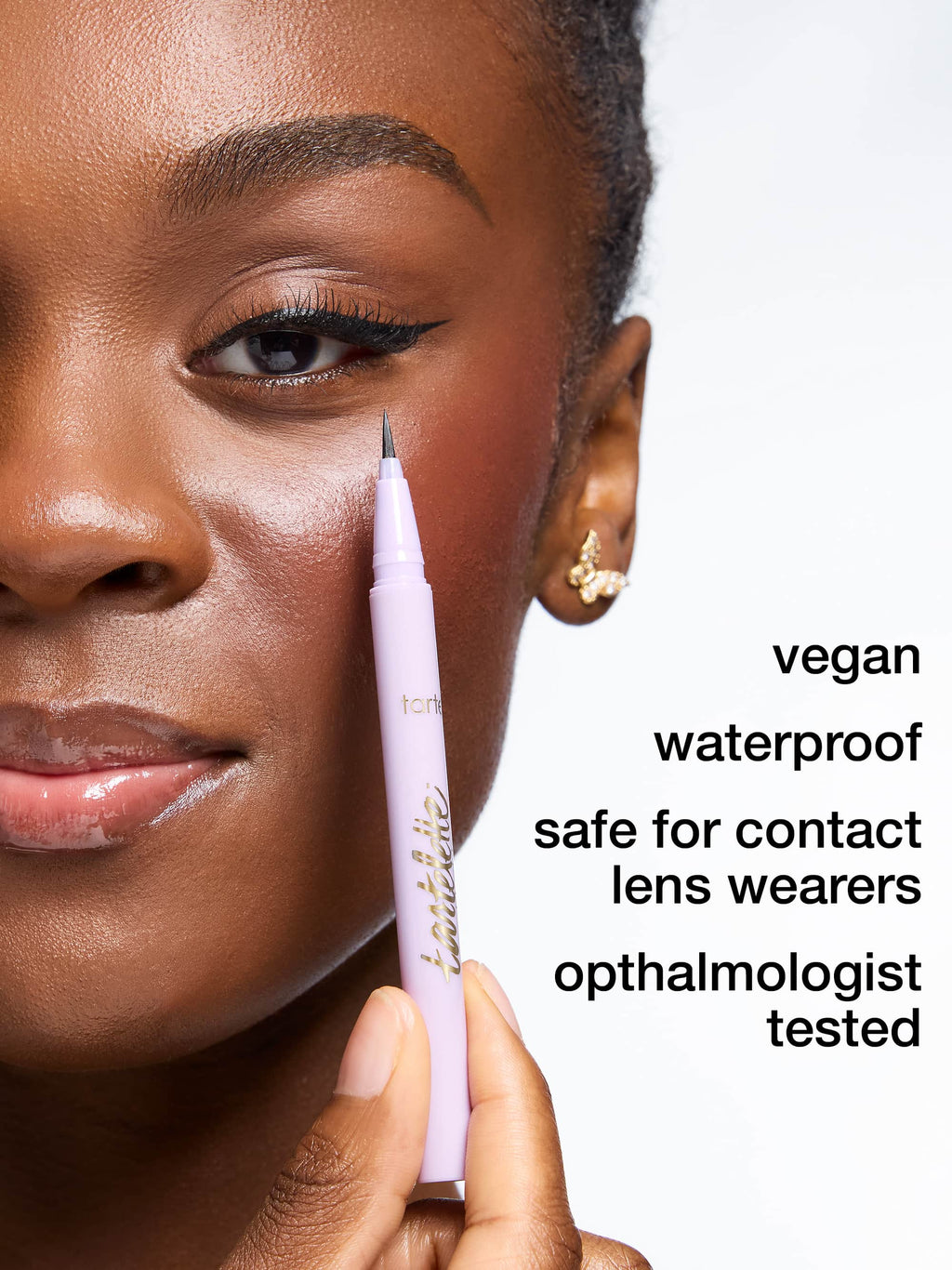 Person applying tartelette quick stick tubing liner with a pen, focusing on the product and its features.