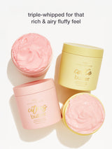 Two containers of 'citrus butter' and one of 'lemon butter' with pink whipped cream on a white background.