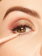 Close-up of a person applying makeup to their eye with a brush.