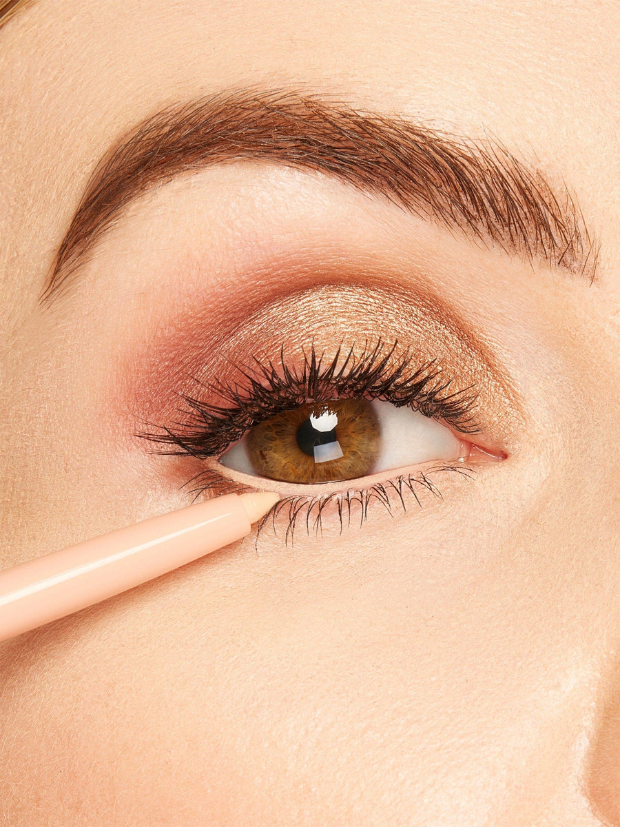 Close-up of a person applying makeup to their eye with a brush.