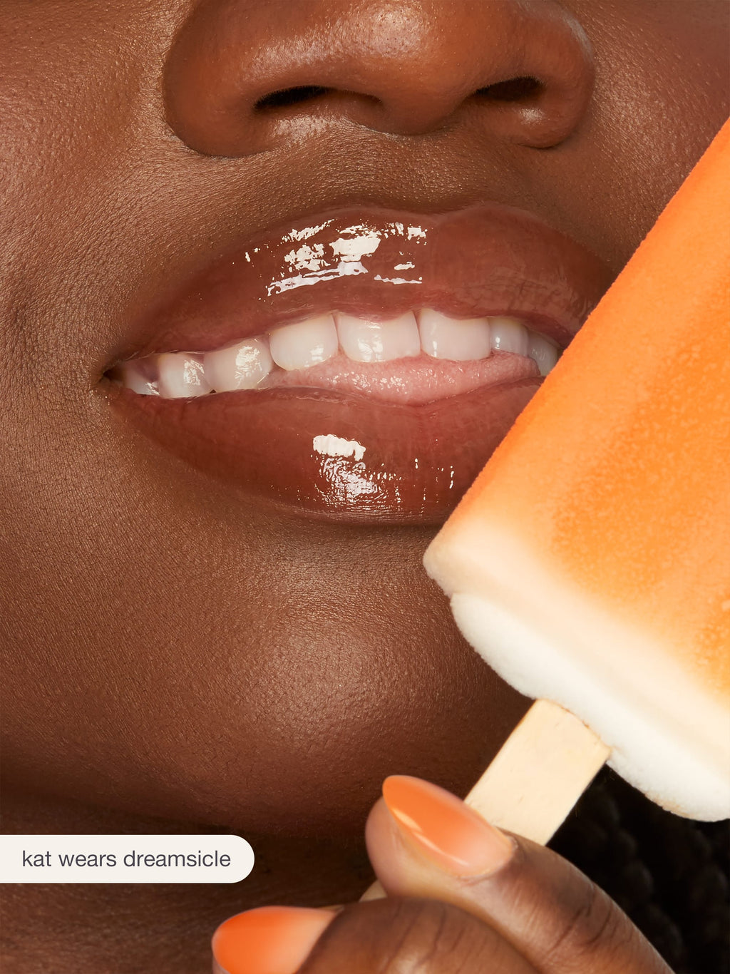 Close-up of a person holding a popsicle with a visible brand name.