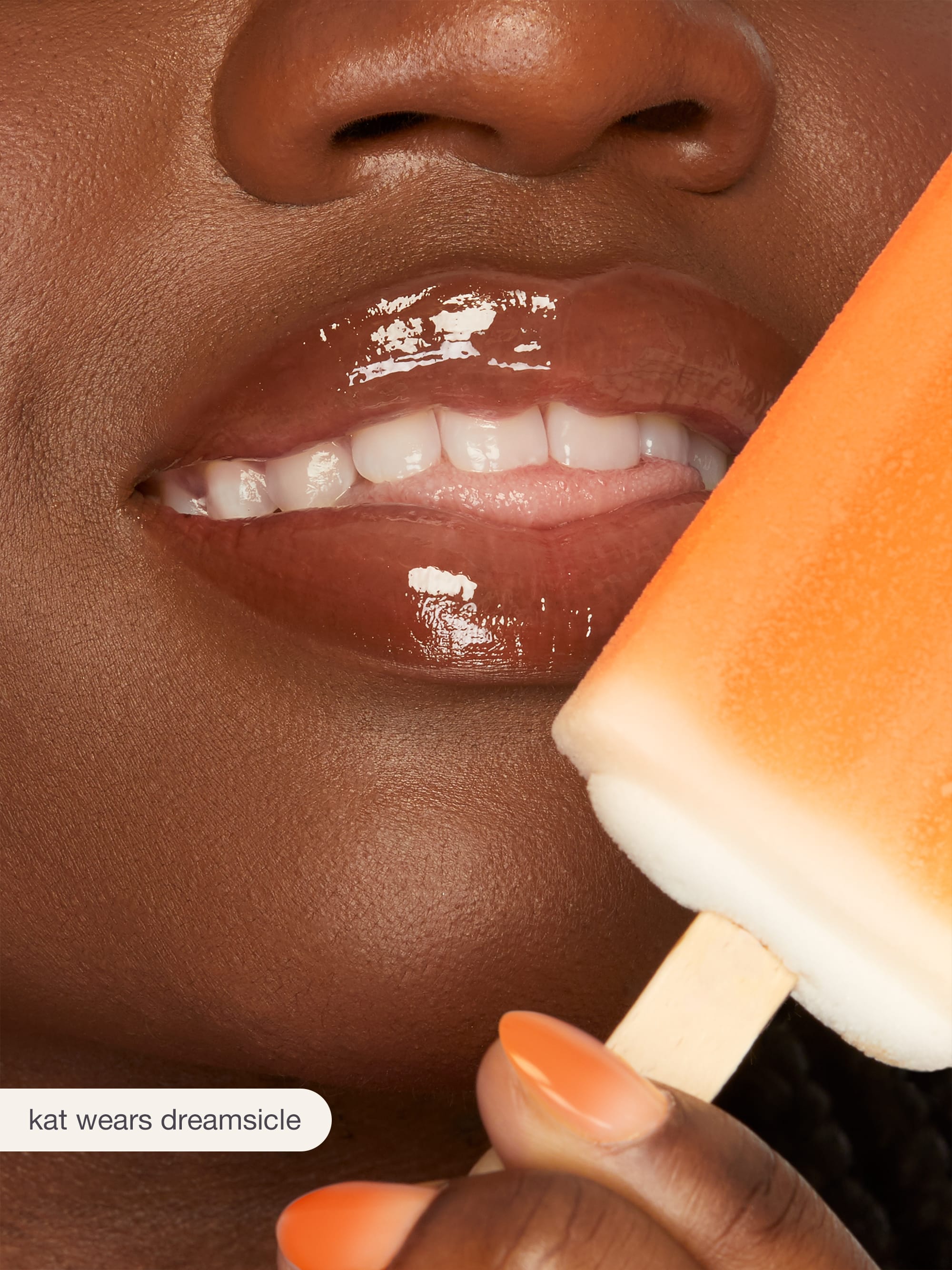 Close-up of a person holding a popsicle with a visible brand name.