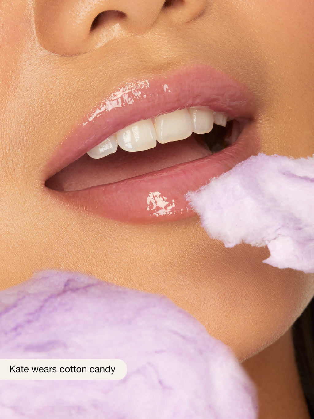 Close-up of a person's lips with cotton candy on a blurred background