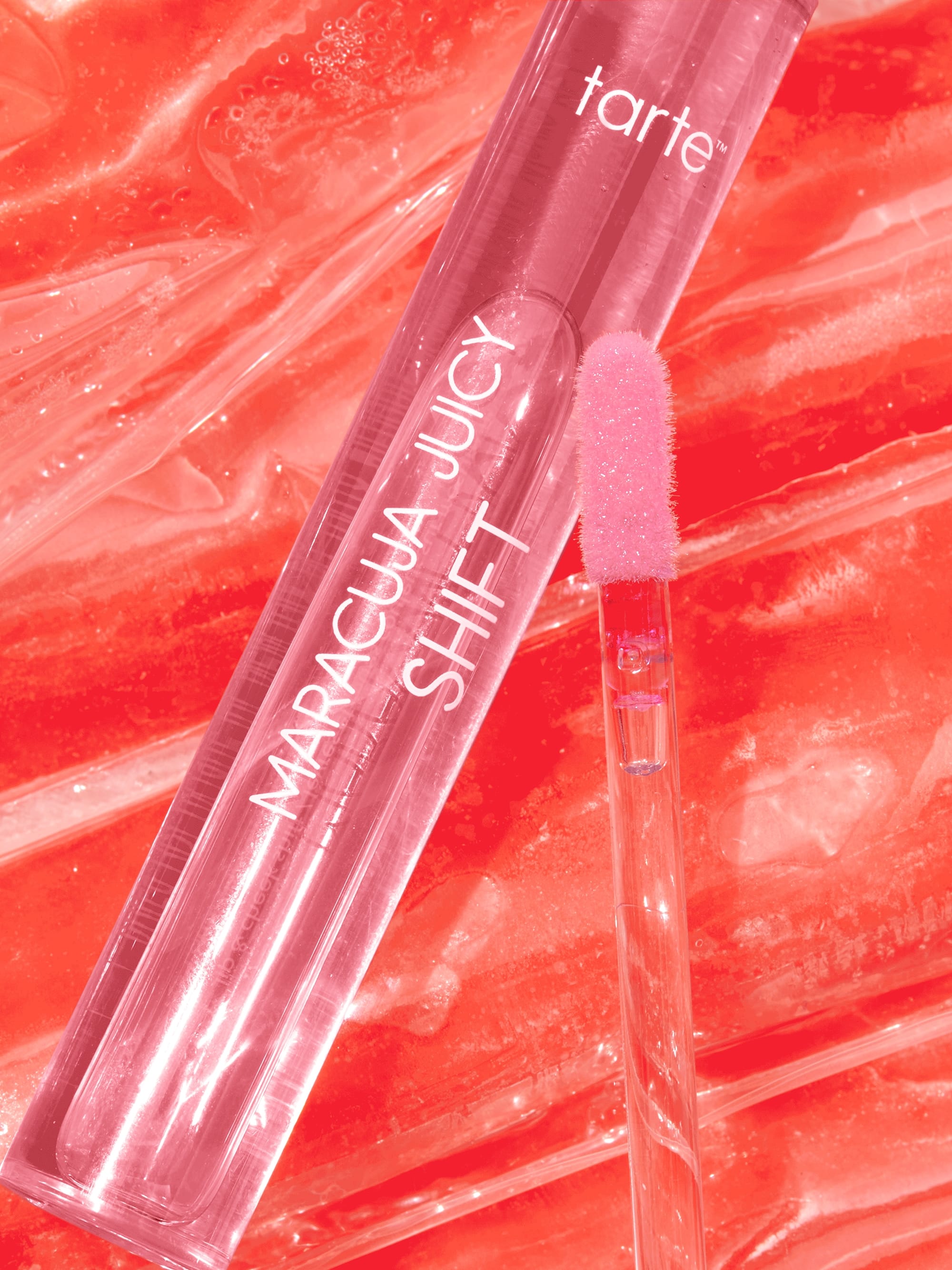 Tarte Maracuja Juicy Shift lip gloss with applicator on a red background