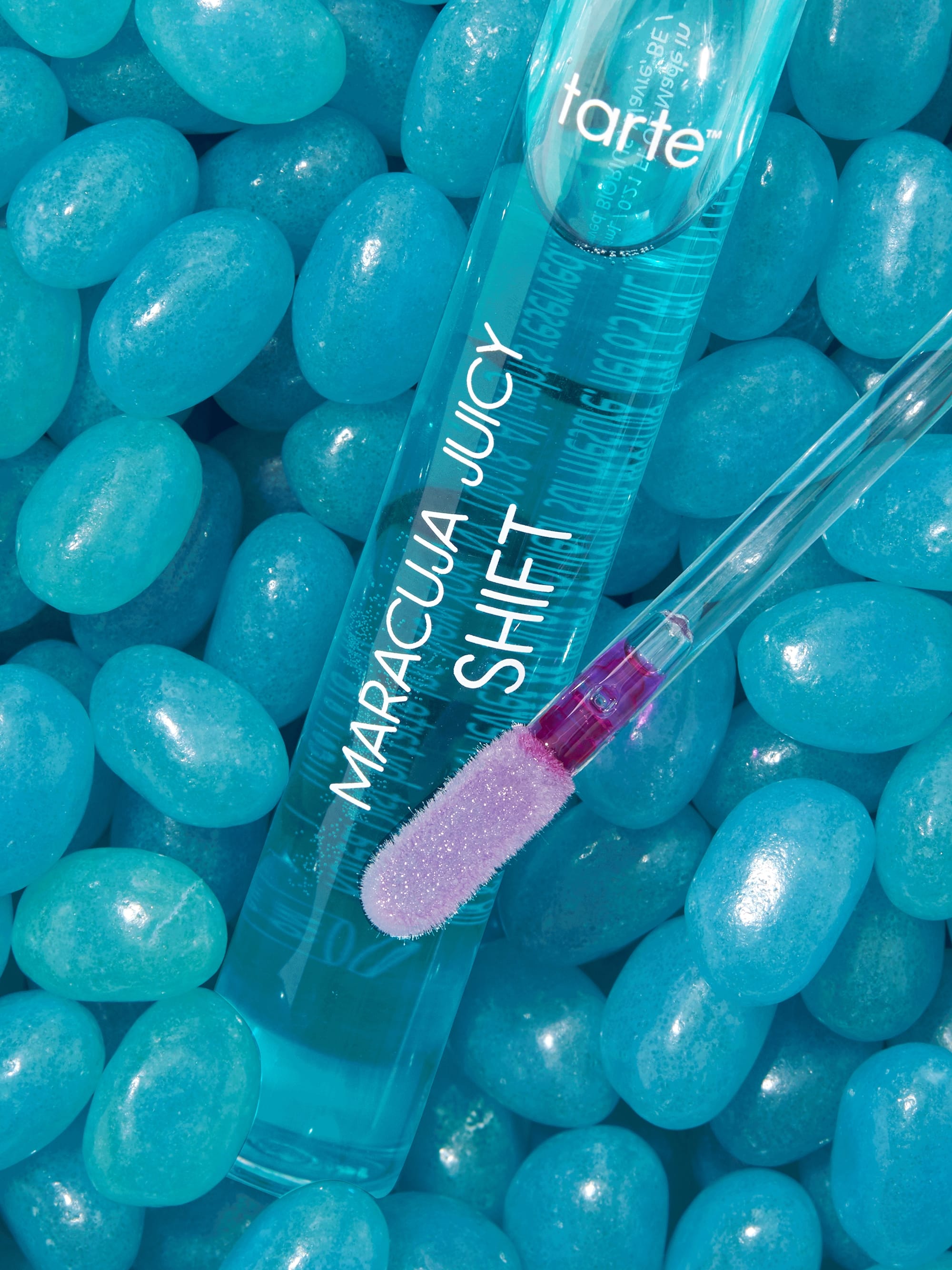Tarte lip product on a bed of blue jelly beans
