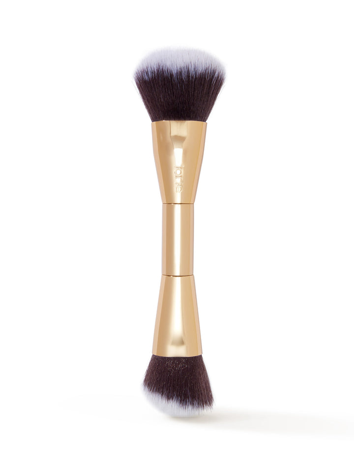 Makeup brush with gold handle and black bristles on a white background