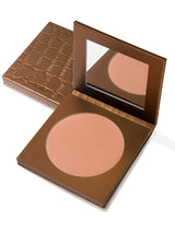 Bronze-colored makeup compact with open lid on a white background
