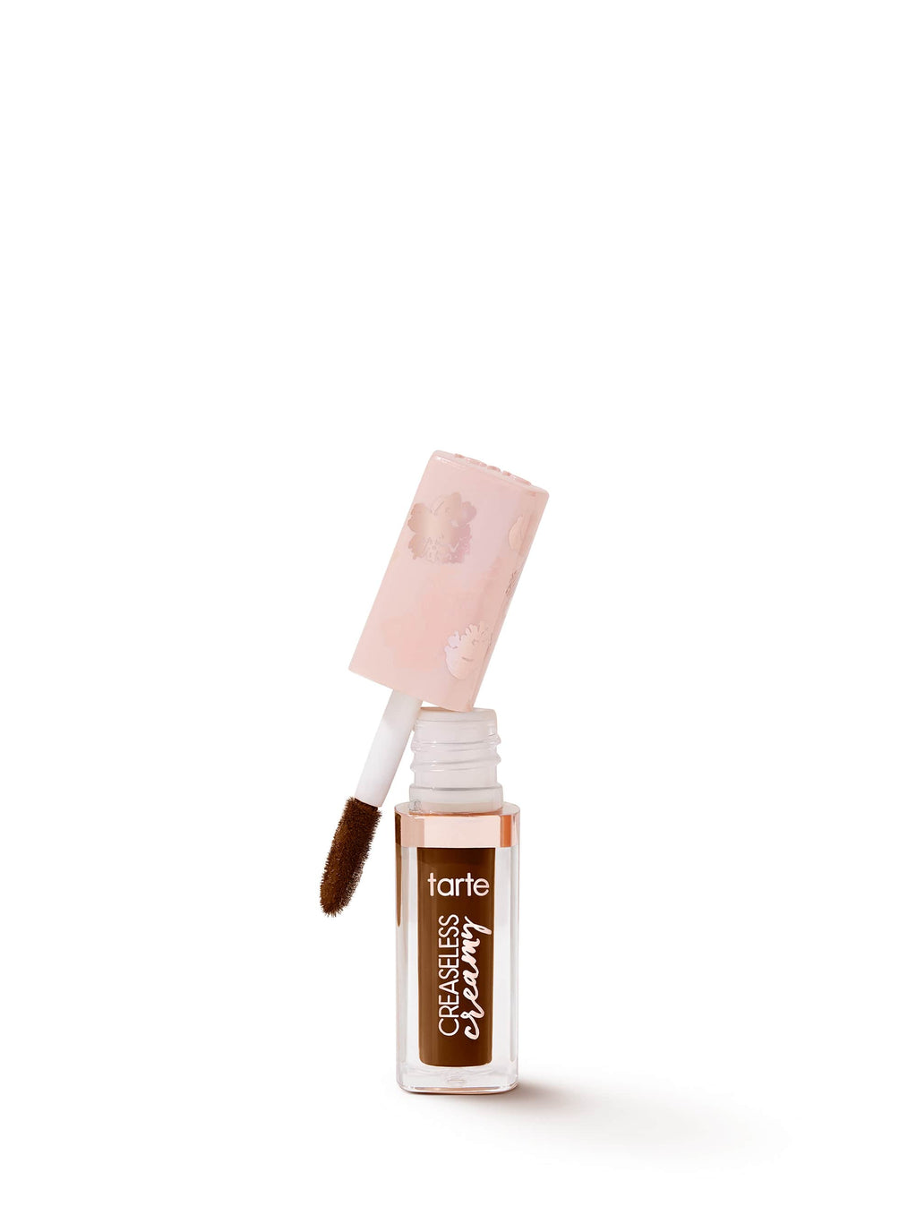 A Tarte Cosmetics concealer bottle stands upright, its cap removed with an applicator attached, filled with rich brown concealer. The background is plain white, emphasizing the product.