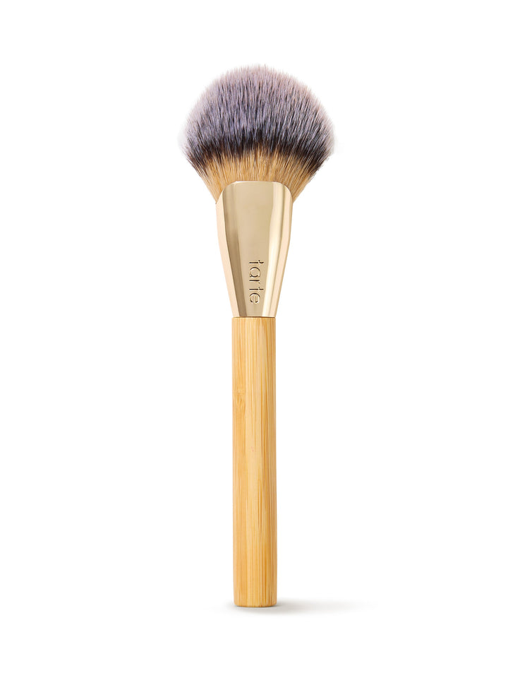 Makeup brush with wooden handle and gold ferrule on a white background